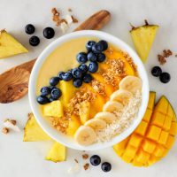 Healthy,Pineapple,,Mango,Smoothie,Bowl,With,Coconut,,Bananas,,Blueberries,And